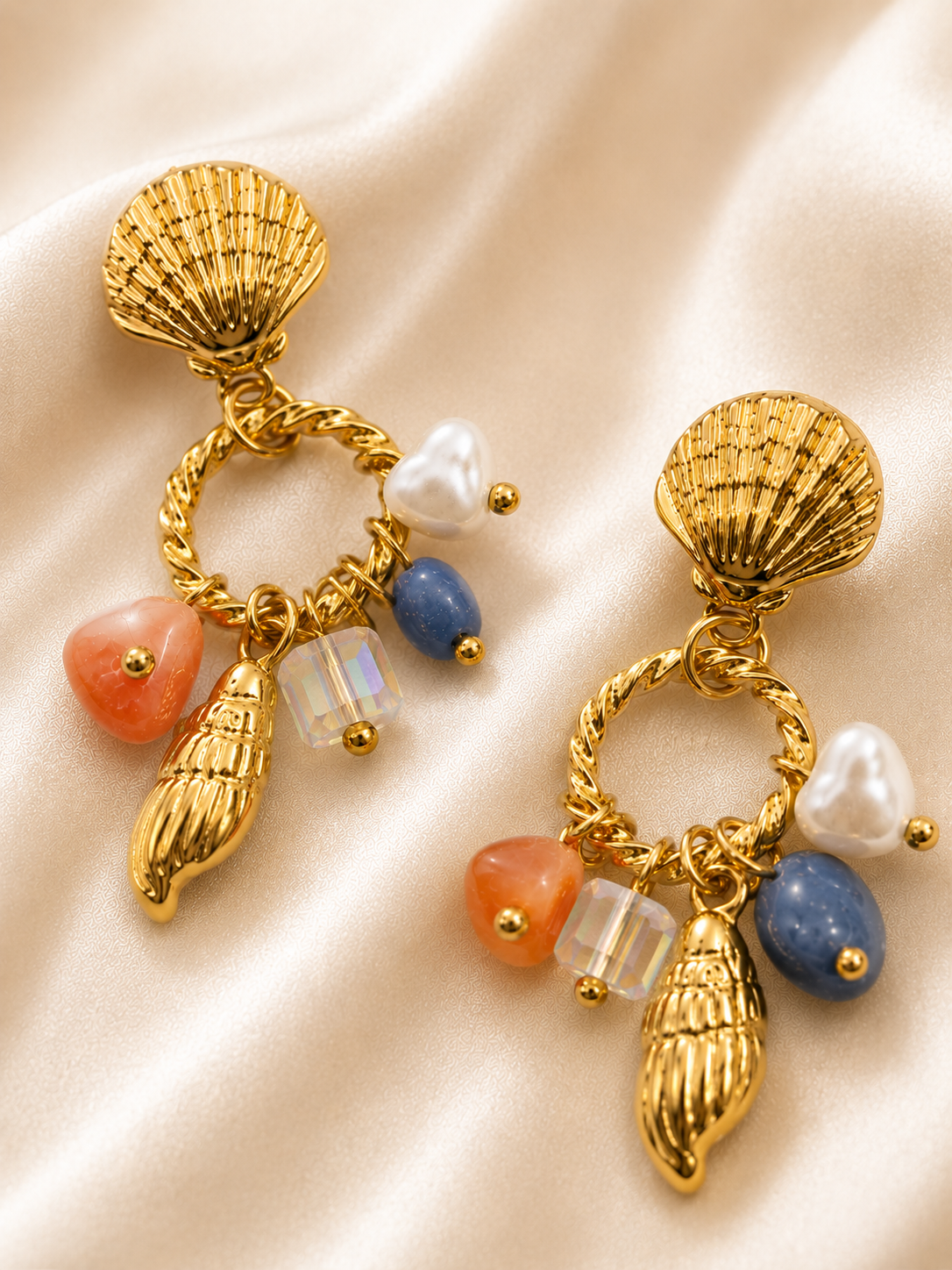 Close-up of Coastal Daydream dangling earrings featuring heart shaped pearl and seashell charms