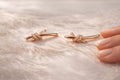 Anti-Tarnish, Ashaarya, Ashaarya Jewels, Ashaarya Jewellery, Rose gold bow-shaped earrings on a soft fabric background