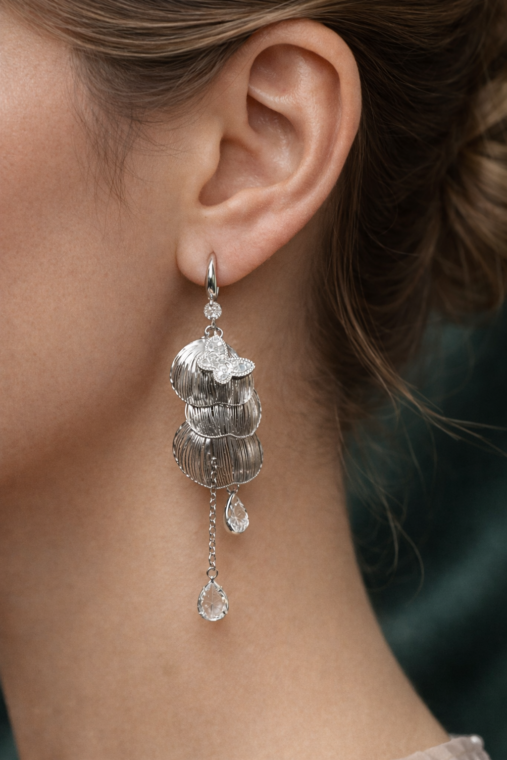 Anti-Tarnish, Ashaarya, Ashaarya Jewels, Ashaarya Jewellery, Close-up of a woman's ear wearing a silver earring with multiple layers and dangling elements.