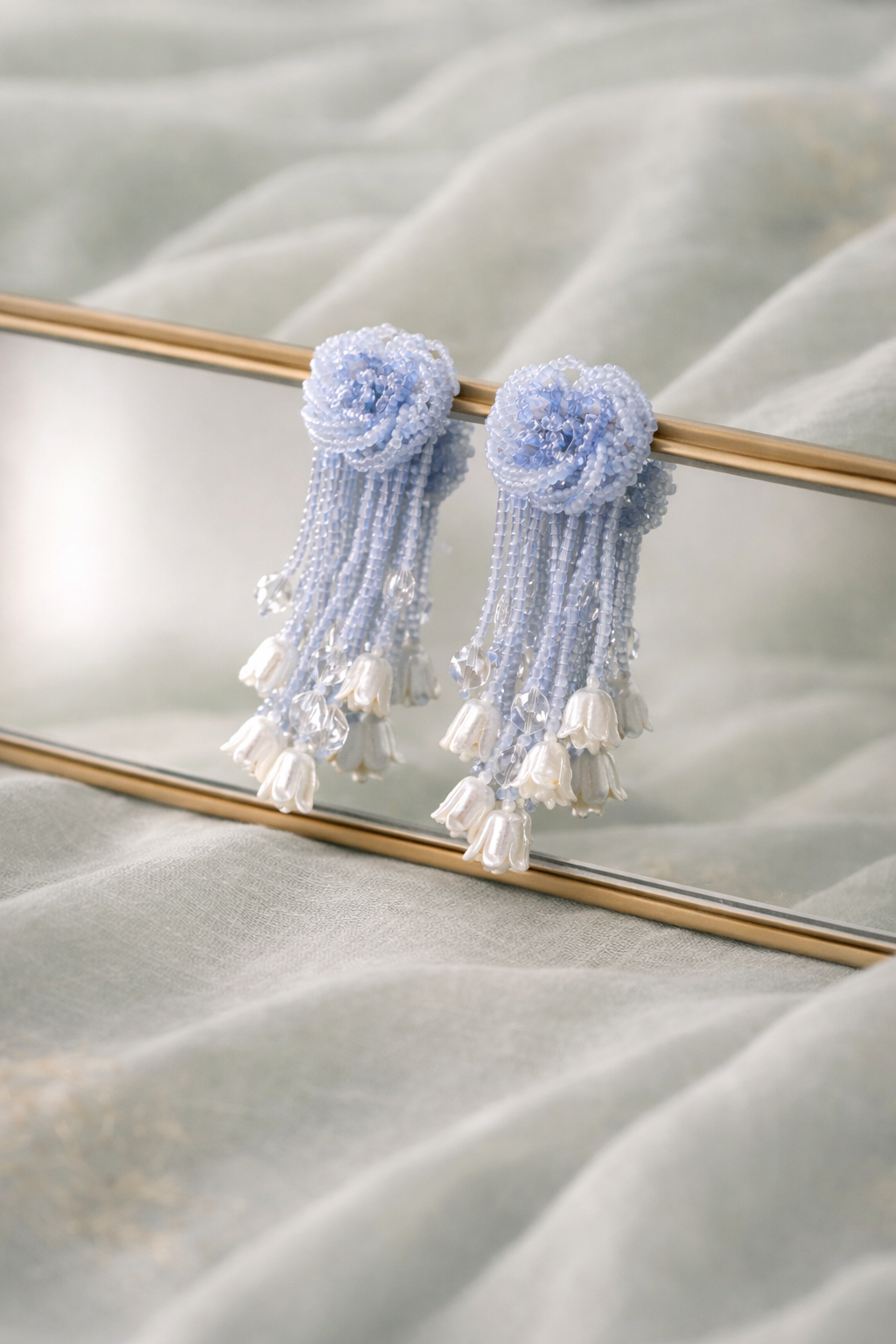 Anti-Tarnish, Ashaarya, Ashaarya Jewels, Ashaarya Jewellery, Light blue floral tassel earrings on a reflective surface