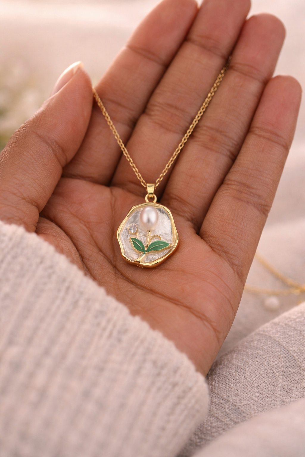 Anti-Tarnish, Ashaarya, Ashaarya Jewels, Ashaarya Jewellery, Gold necklace with a pendant held in a hand against a blurred background