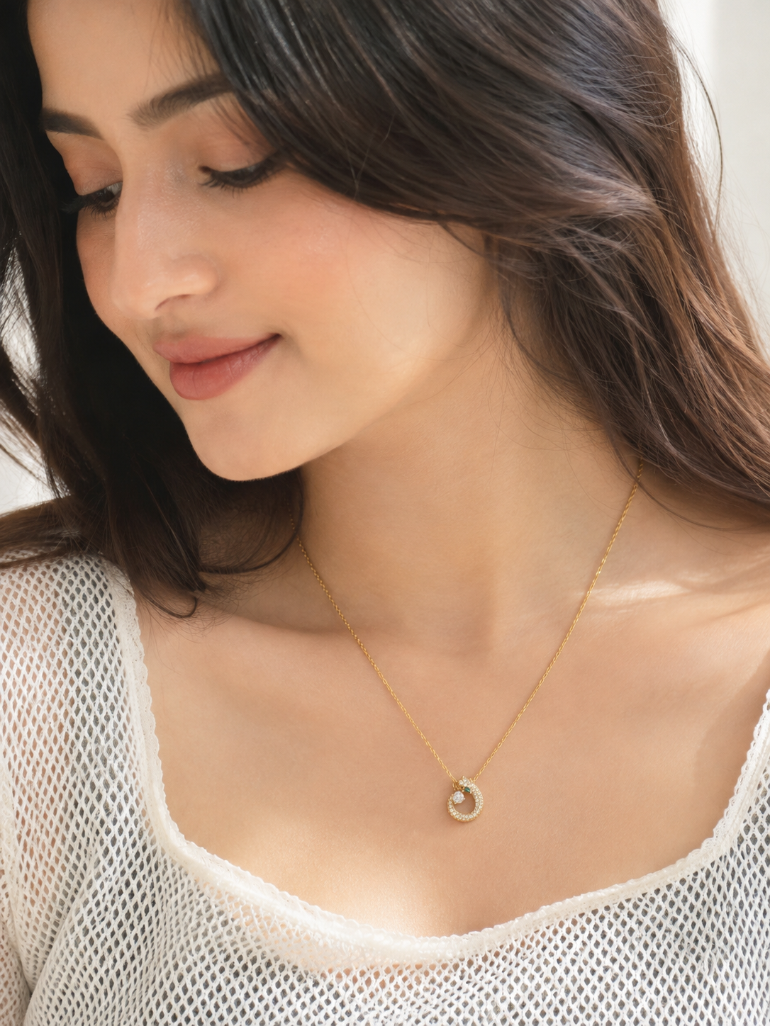 Front view of the gold-tone pendant necklace with American diamond embellishments