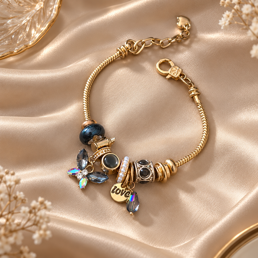 Ashaarya gold-tone charm bracelet styled on the wrist, featuring 9 statement charms and a 316L stainless steel base for an elegant jewellery look.