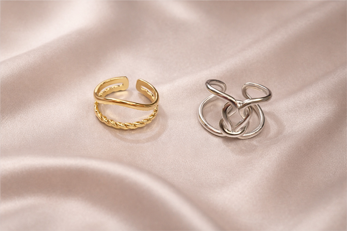 Anti-tarnish gold and silver duo ring stack worn on hand — adjustable comfort jewellery featuring twisted band and knot design, band rings for women, statement rings for women. Two gold and silver rings on a soft pink fabric background