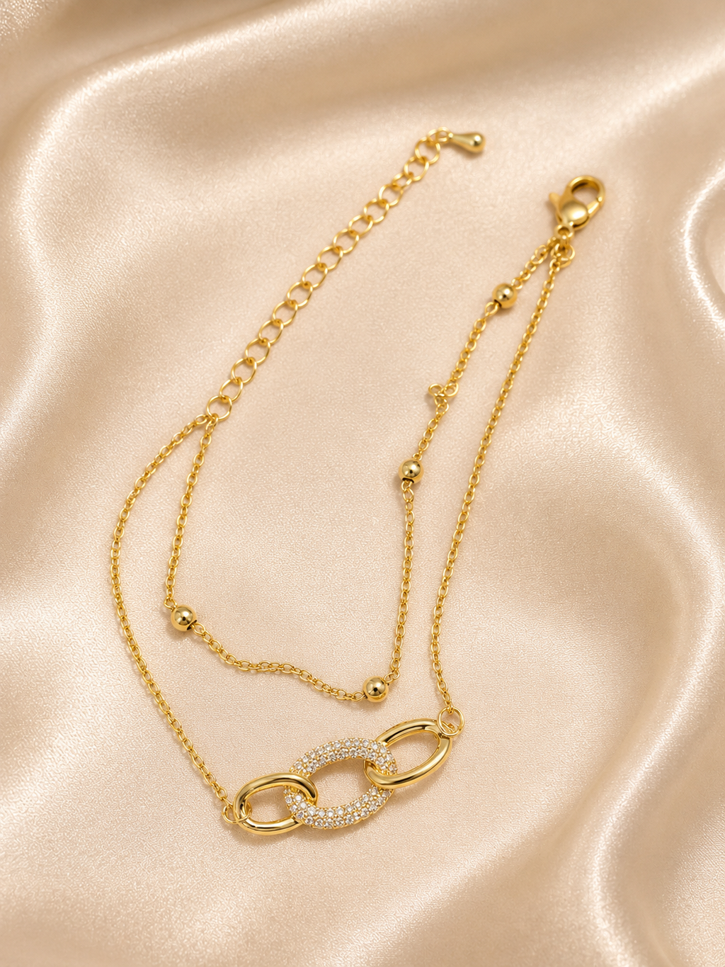 Interlink Dual Chain Bracelet by Ashaarya featuring a crystal-studded interlocking link in 18KT gold plated 316L stainless steel. Lightweight, anti-tarnish bracelet for women.