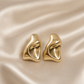 Anti-tarnish gold clip-on hoop earrings for women featuring a bold sculptural curved design and comfortable no-piercing closure