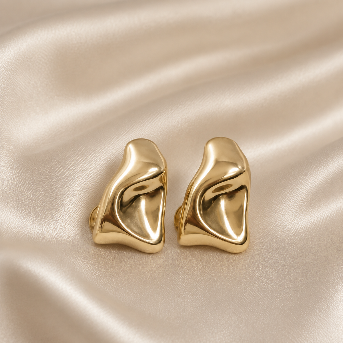 Anti-tarnish gold clip-on hoop earrings for women featuring a bold sculptural curved design and comfortable no-piercing closure
