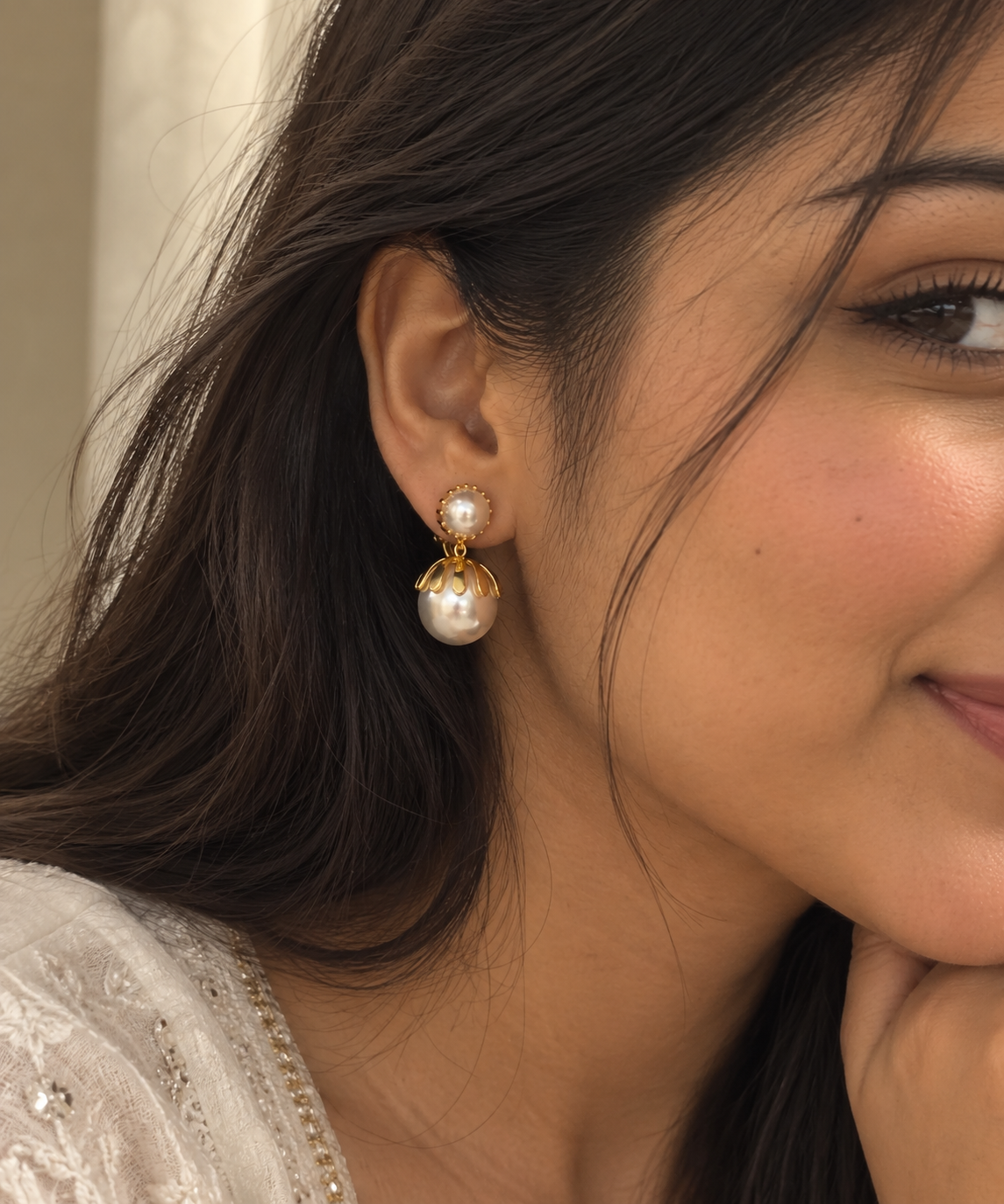 Anti-tarnish pearl earrings for women featuring elegant gold detailing, round pearl studs and large pearl drops, photographed on champagne satin