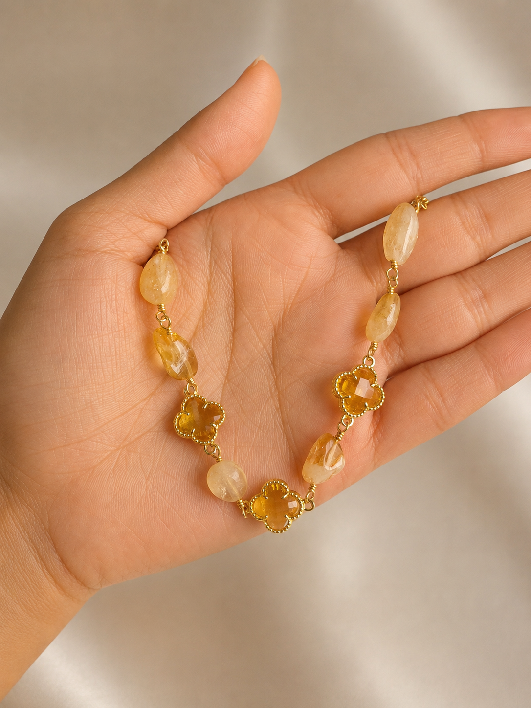 Anti-tarnish gold and yellow stone bracelet with faceted clover-shaped accents, natural stone beads and a polished gold-tone finish