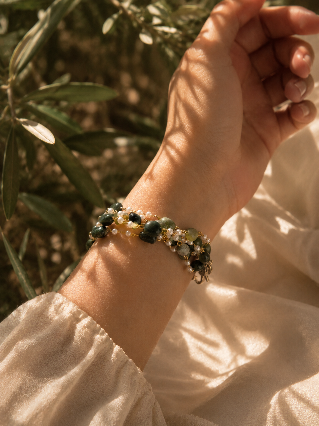 Anti-tarnish green gemstone bracelet for women featuring organic-shaped green stones, white pearl accents and refined gold-tone detailing