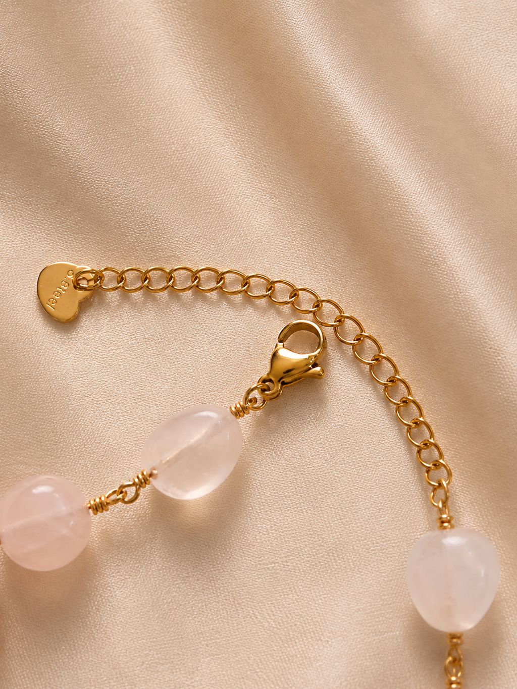 Anti-tarnish pink stone bracelet with delicate clover-shaped accents, polished gemstone beads and an elegant gold-tone finish