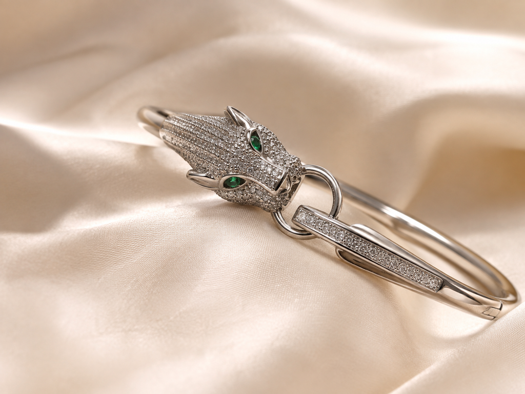 Anti-tarnish statement panther bracelet with a silver-tone sculptural design, crystal detailing and distinctive green gemstone eyes