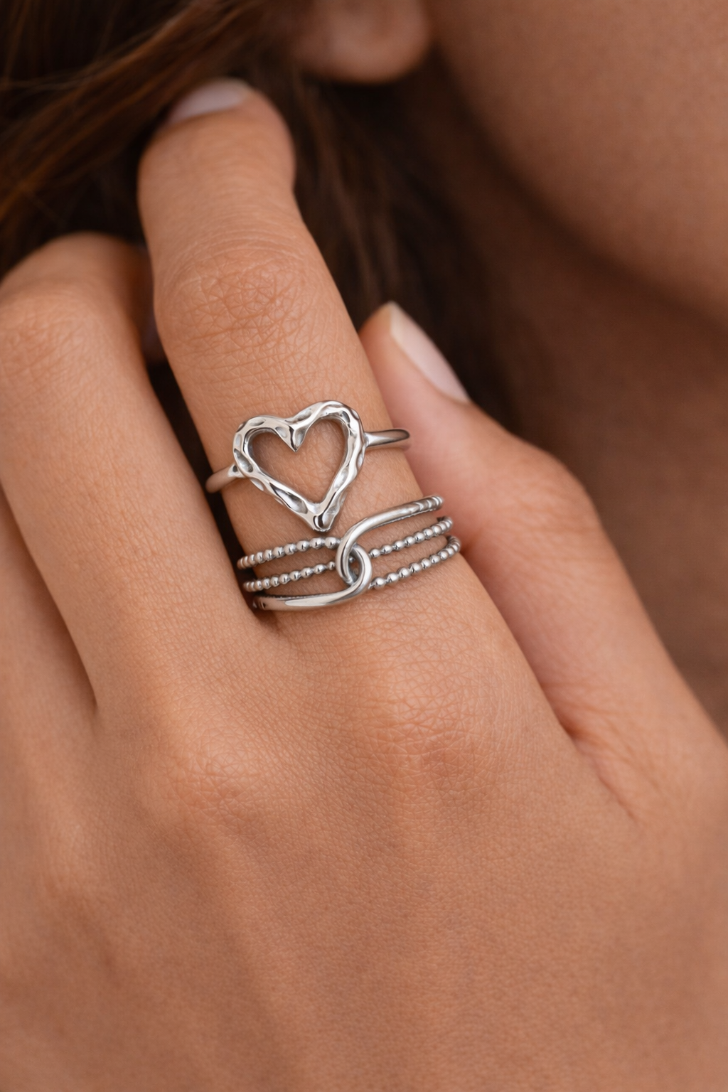 Anti-Tarnish, Ashaarya, Ashaarya Jewels, Ashaarya Jewellery, Silver heart-shaped ring on a finger with a blurred background