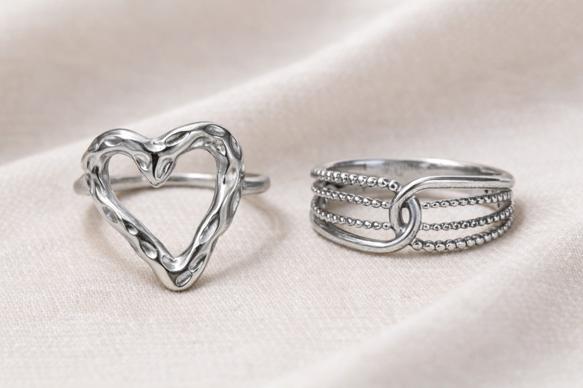 Anti-Tarnish, Ashaarya, Ashaarya Jewels, Ashaarya Jewellery, Two silver rings, one heart-shaped and one with multiple bands, on a light pink fabric background.
