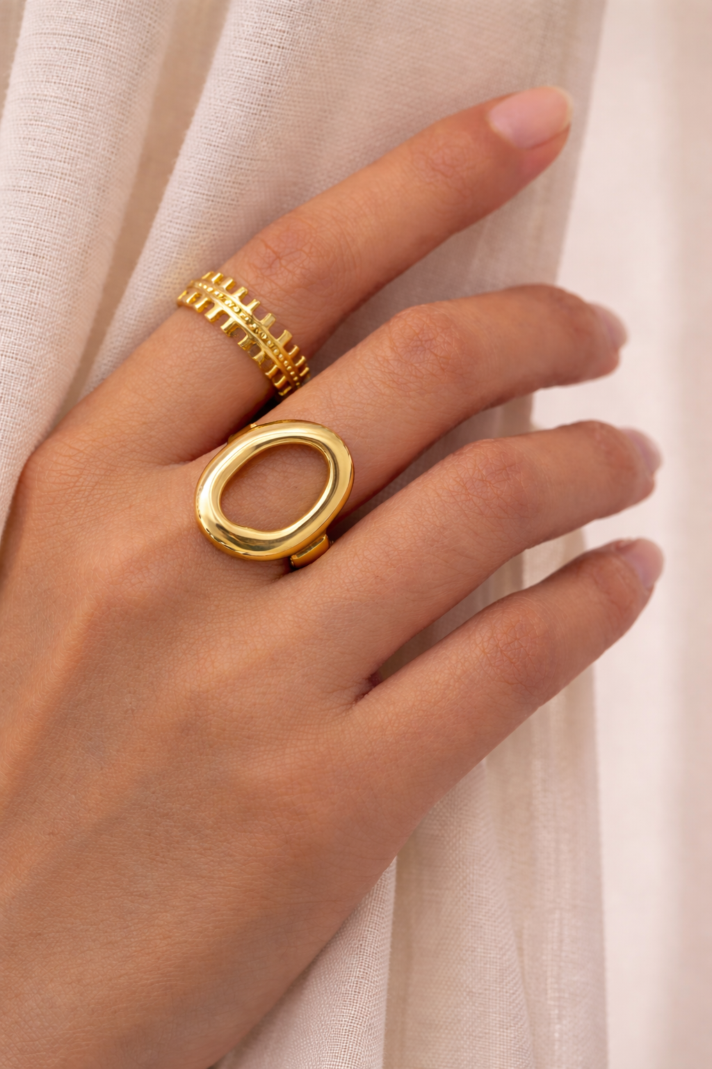 Anti-Tarnish, Ashaarya, Ashaarya Jewels, Ashaarya Jewellery, Hand wearing two gold rings on a light background