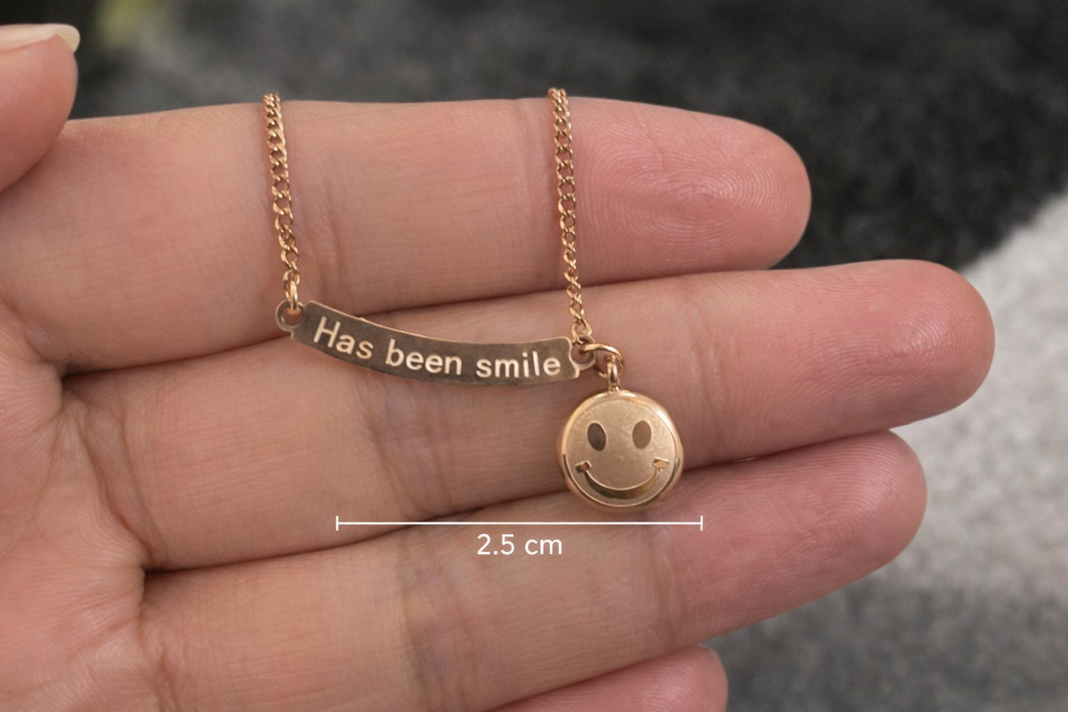 Anti-Tarnish, Ashaarya, Ashaarya Jewels, Ashaarya Jewellery, Gold necklace with a smiley face pendant held between fingers, showing measurement details.