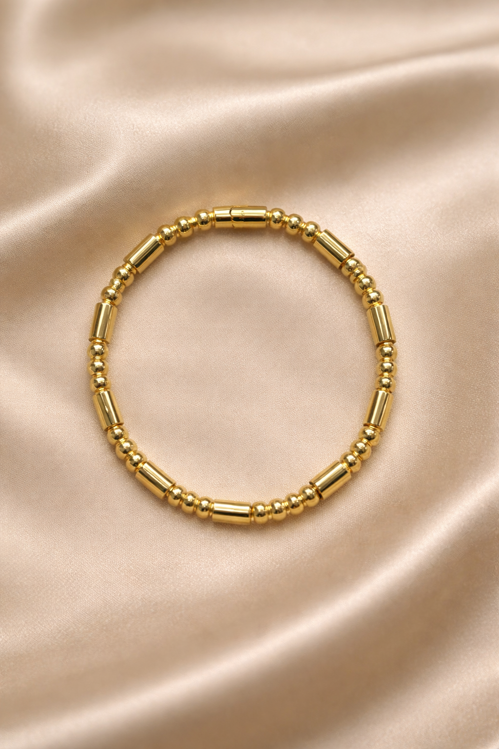 Ashaarya, Ashaarya jewels, ashaarya jewellery, charm bracelets, Gold beaded bracelet on a beige satin background