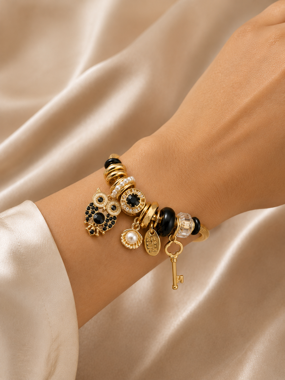 Lifestyle image of the Noir Wisdom Charm Bracelet styled with neutral tones for an elegant everyday jewellery look.