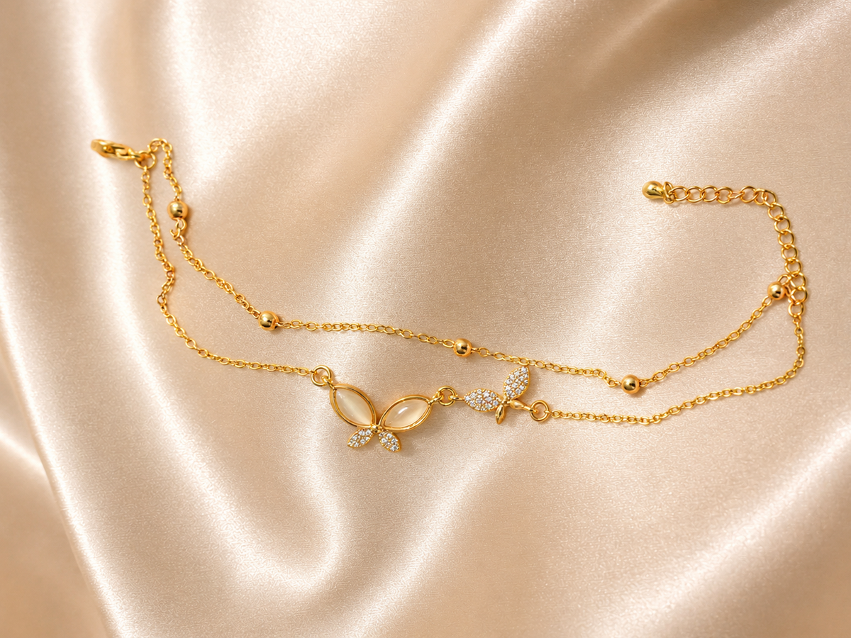 Close-up of the Whispering Wings Bracelet by Ashaarya showcasing crystal butterfly motifs, dual chains, and anti-tarnish 18KT gold plating.