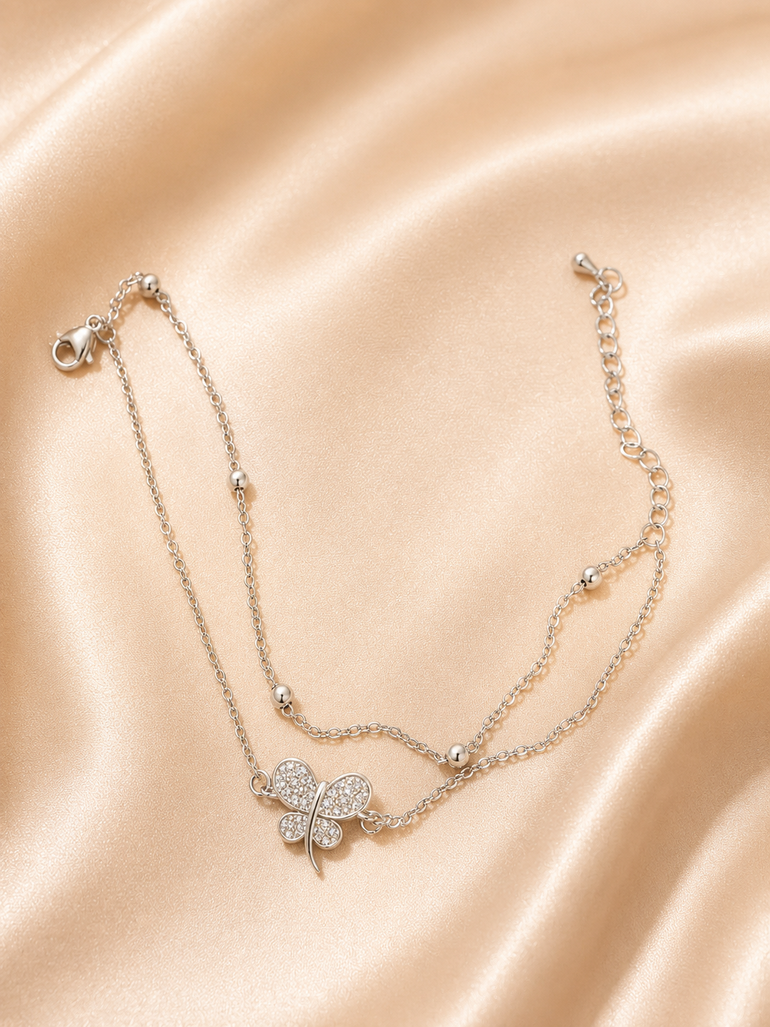 The Becoming Bracelet by Ashaarya featuring a sparkling silver butterfly charm on a dual-chain anti-tarnish 316L stainless steel bracelet for women.