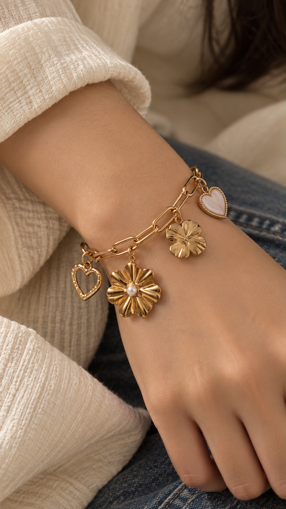 Gold-tone floral and clover-inspired charms on Ashaarya's paperclip chain bracelet, styled for an elegant jewellery look.
Copy filename