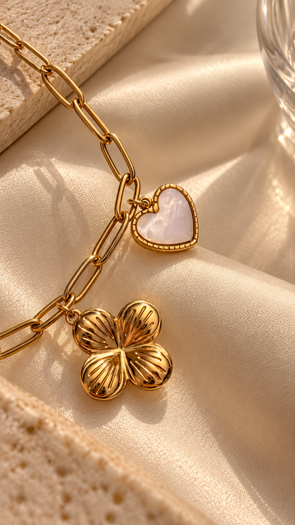 Close-up of the gold charm bracelet by Ashaarya showing an open heart charm and sculpted flower pendant with a pearl-like centre.
Copy filename