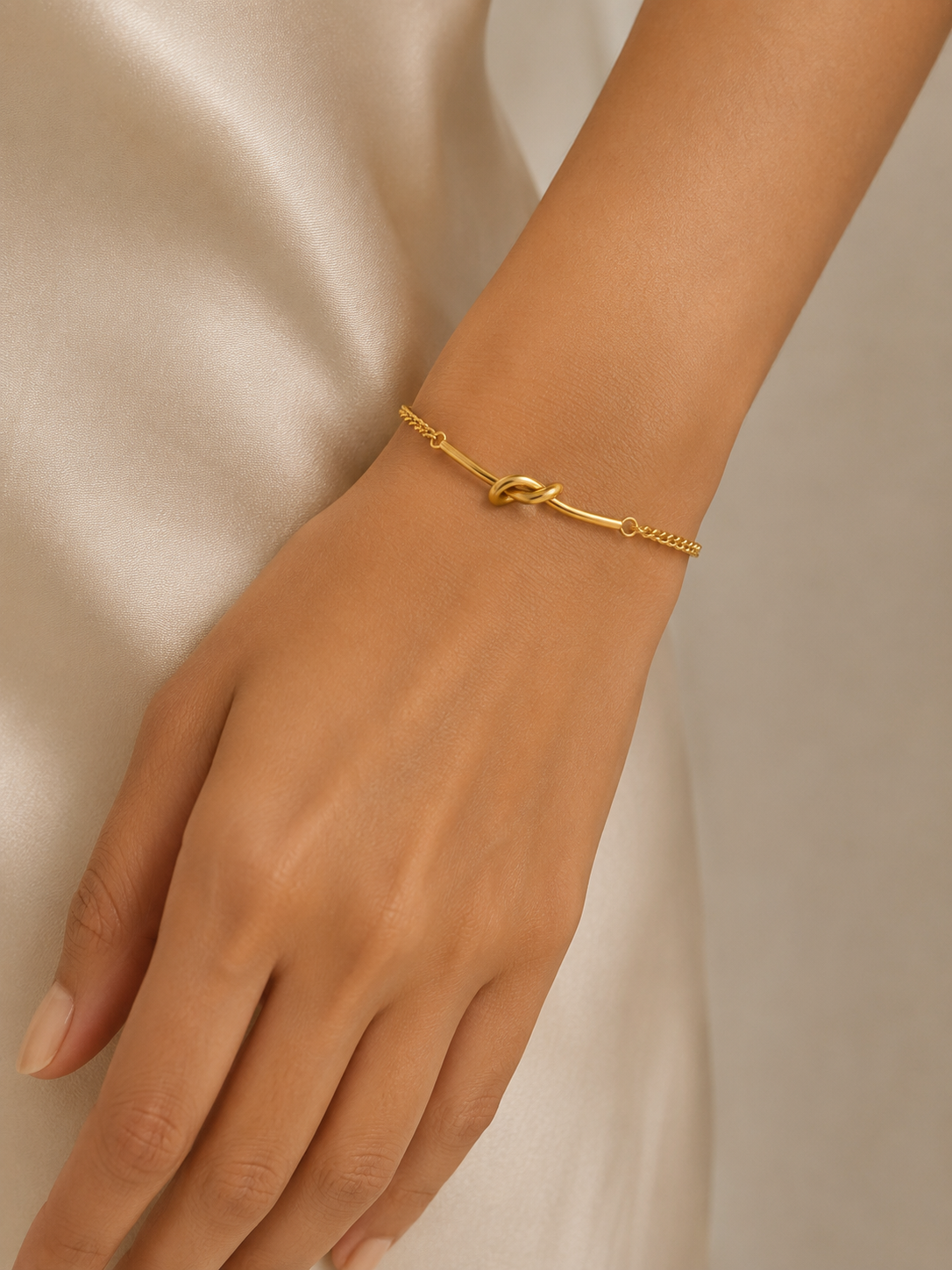Macro close-up of Ashaarya's anti-tarnish stainless steel knot bracelet, highlighting the polished gold finish and premium detailing.