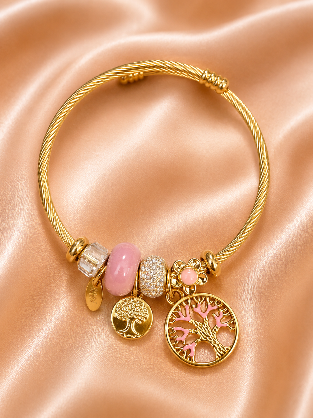 Pink charm bracelet for women featuring Tree of Life pendant, floral charm, crystal beads and lightweight skin-friendly comfort jewellery design.