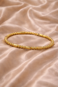 Ashaarya, Ashaarya jewels, ashaarya jewellery, charm bracelets, Gold bracelet on a beige fabric background