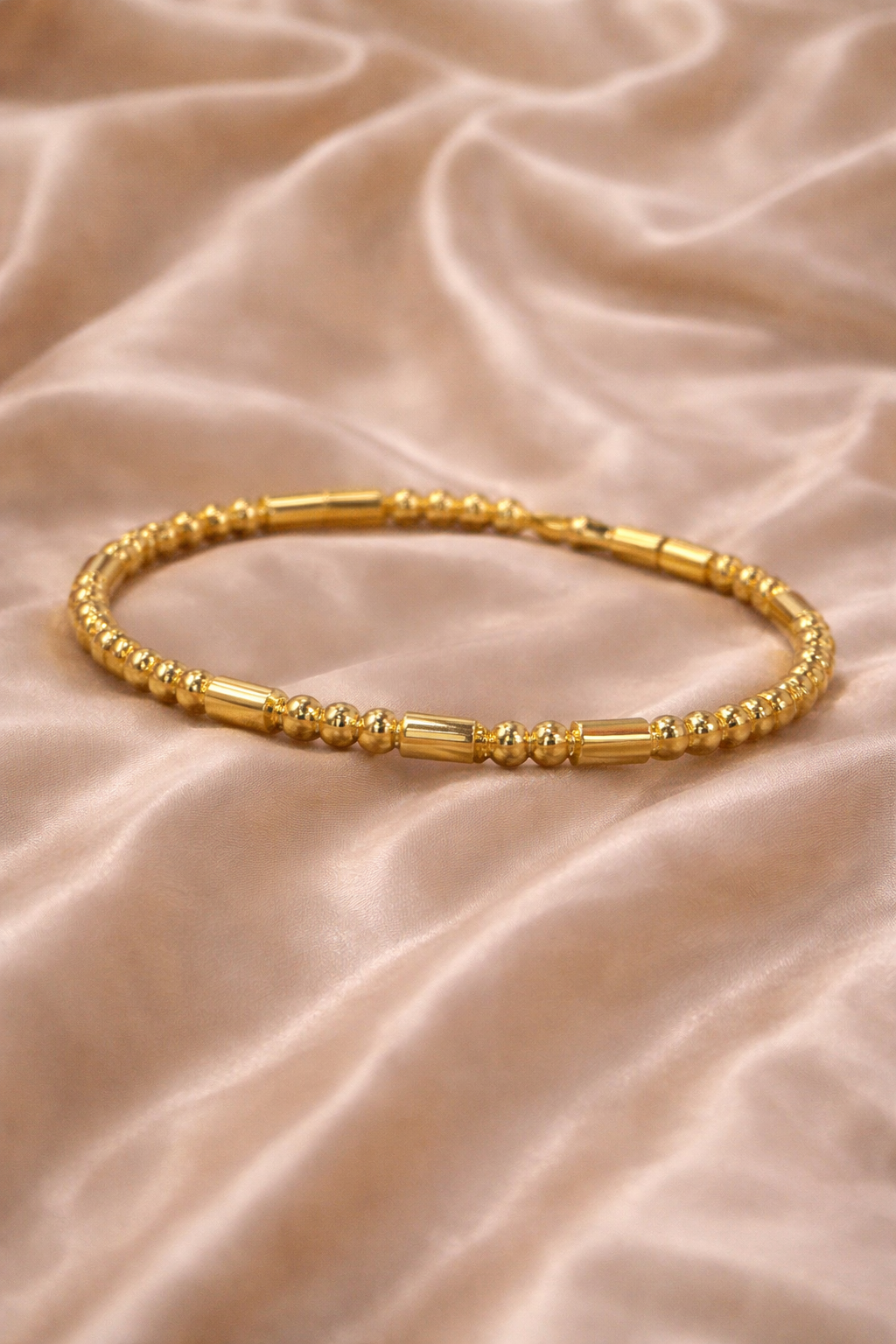 Ashaarya, Ashaarya jewels, ashaarya jewellery, charm bracelets, Gold bracelet on a beige fabric background