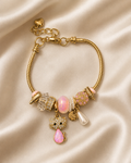 Kitty Keepsake Charm Bracelet by Ashaarya in 18KT gold tone with pink charms and crystal kitty pendant. cat charm bracelet, cute charm bracelet, gold charm bracelet for women, anti tarnish charm bracelet, 316L stainless steel bracelet, lightweight bracelet, pink charm bracelet, comfort jewellery, Ashaarya charm bracelet
