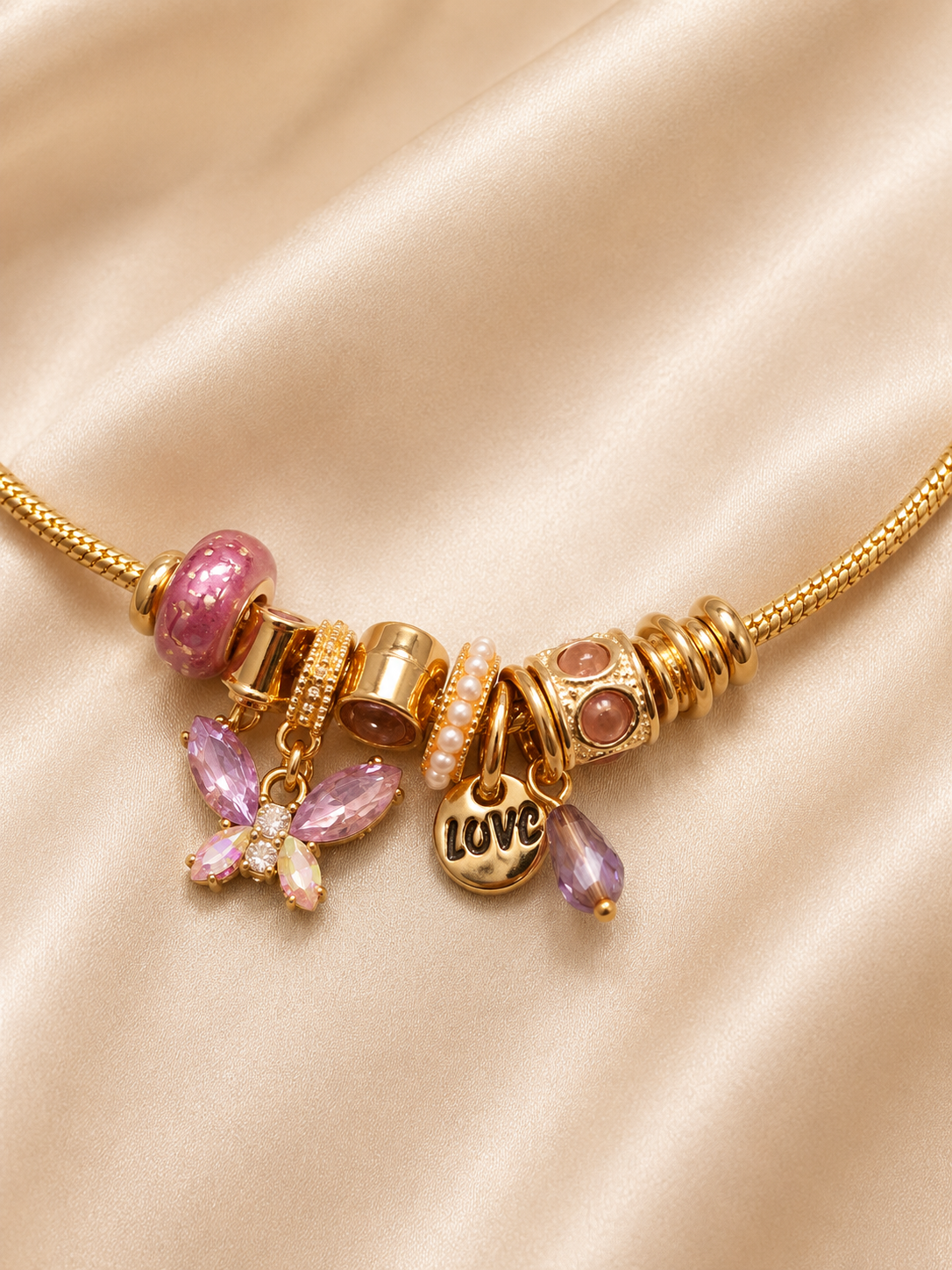 Close-up of Lavender Daydream Charm Bracelet by Ashaarya showcasing butterfly, Love charm and crystal detailing.