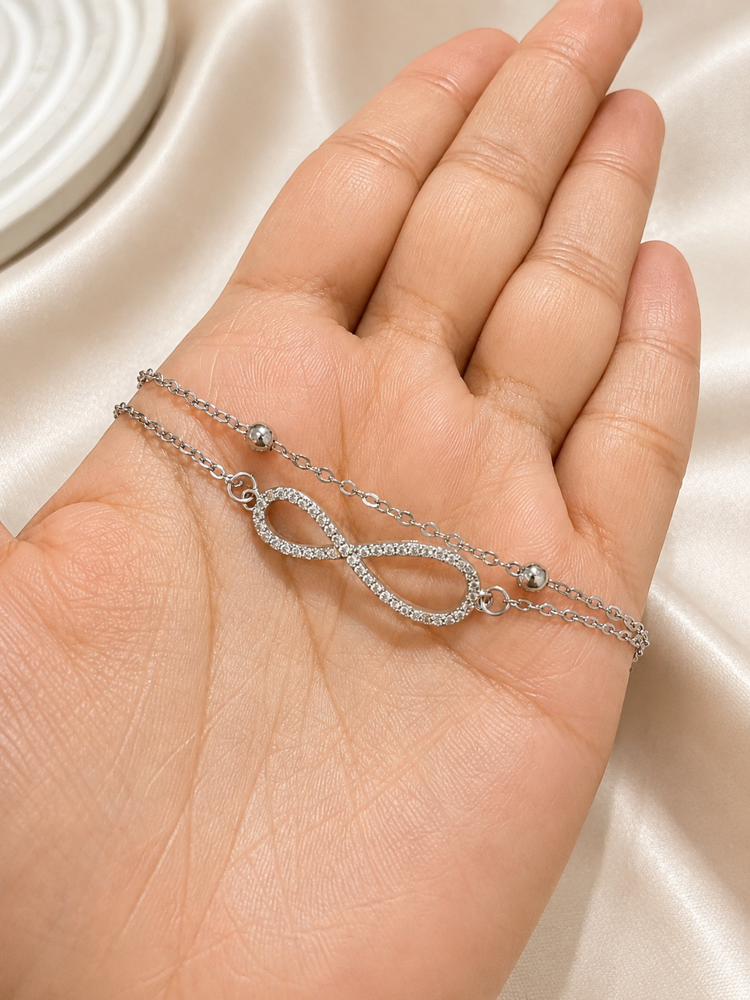 Model wearing the Infinite Journey Bracelet by Ashaarya, a minimalist anti-tarnish silver bracelet made with hypoallergenic 316L stainless steel.