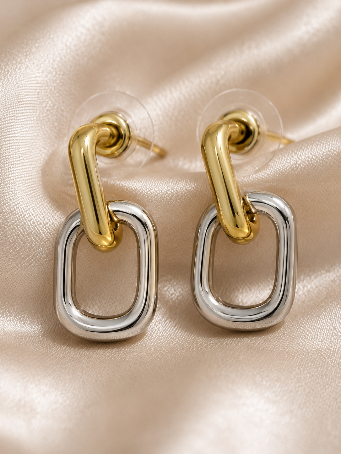 Gold and silver hoop earrings on a beige background. two tone earrings, gold and silver earrings, stainless steel earrings, anti tarnish earrings, lightweight earrings, statement earrings for women, geometric earrings, modern earrings, link earrings, everyday earrings, skin friendly jewellery, comfort jewellery