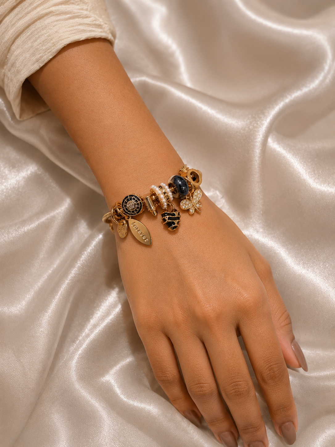 Midnight Monarch Charm Bracelet by Ashaarya featuring black enamel charms with an 18KT gold tone finish. charm bracelet, black charm bracelet, butterfly charm bracelet, gold charm bracelet for women, anti tarnish jewellery, 316L stainless steel jewellery, lightweight bracelet, skin friendly jewellery, adjustable bracelet, everyday bracelet, demi fine jewellery, statement charm bracelet, luxury charm bracelet, comfort jewellery, Ashaarya charm bracelet