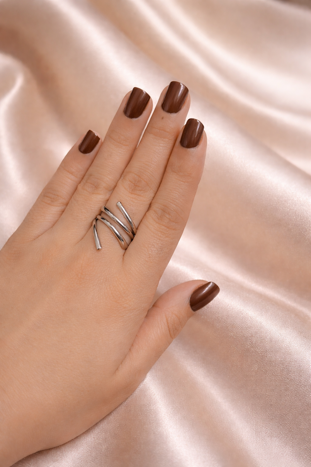 Noor Jaal anti-tarnish statement ring adjustable silver band rings for women comfort jewellery statement rings for women Ashaarya Hand wearing a silver ring with brown nail polish on a satin background