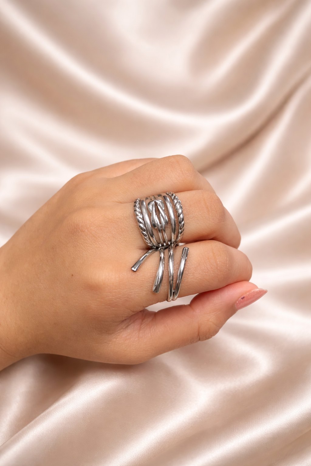 Noor Jaal anti-tarnish statement ring adjustable silver band rings for women comfort jewellery statement rings for women Ashaarya 
Hand wearing multiple silver rings on a beige fabric background