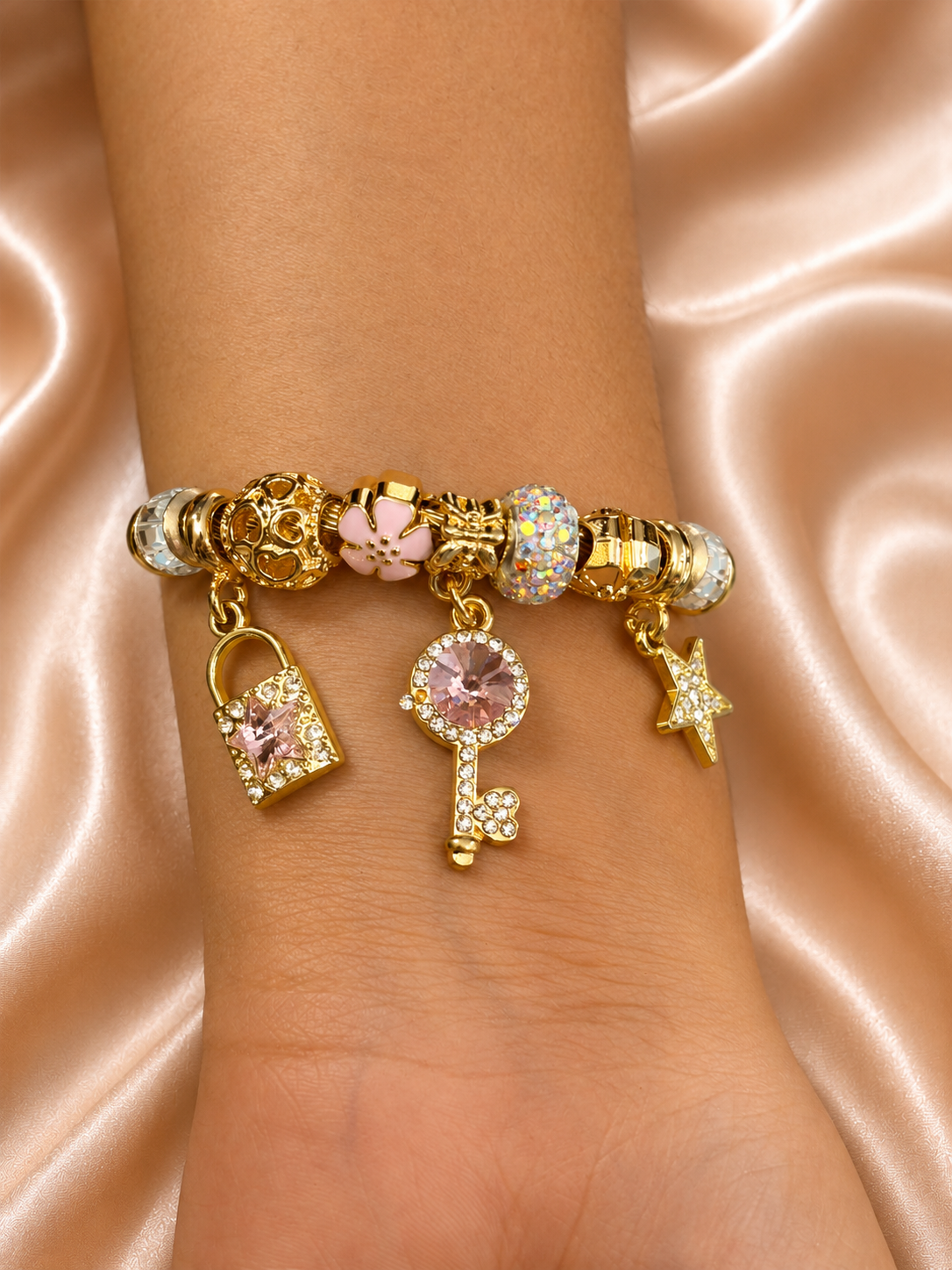 Close-up of Pink Starlight Cute Charm Bracelet featuring sparkling lock, key, flower and star charms in anti-tarnish comfort jewellery design.