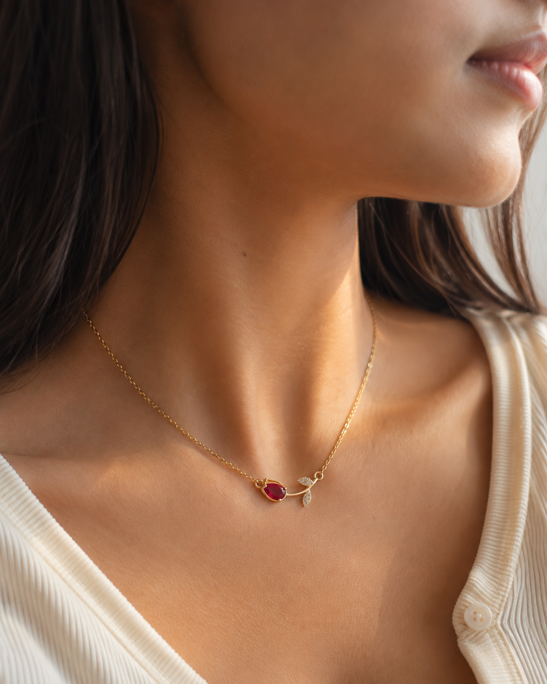 Delicate red gemstone necklace for women with a fine gold-tone chain and sparkling leaf-inspired pendant design