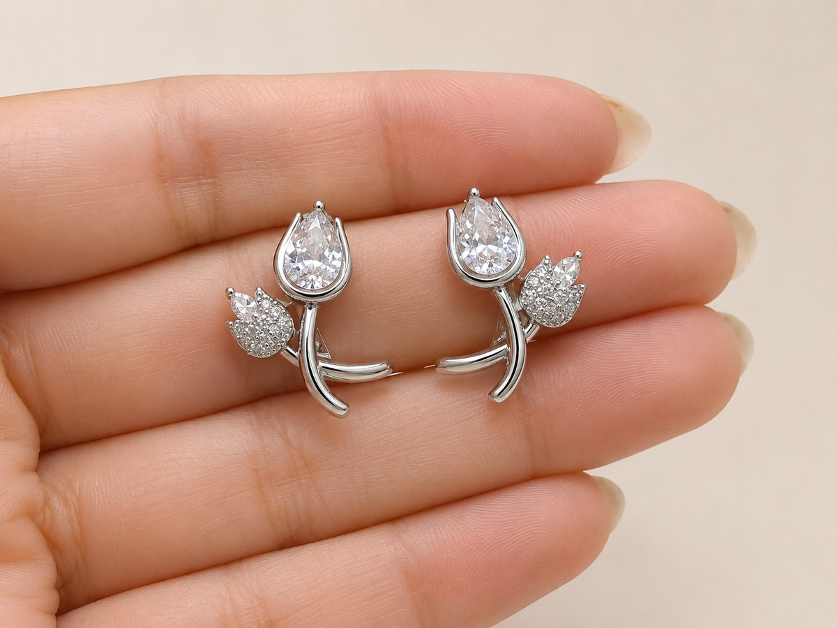 Silver-tone crystal clip-on earrings for women featuring a large pear-shaped crystal and delicate floral stone design