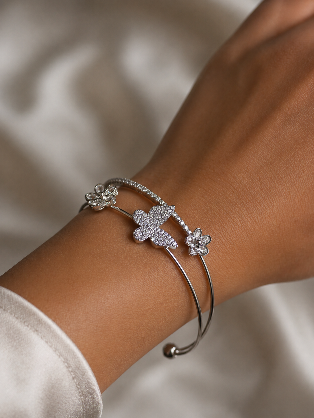 Delicate floral accents and sparkling stone details on the Silver Butterfly Bloom Bracelet by Ashaarya.