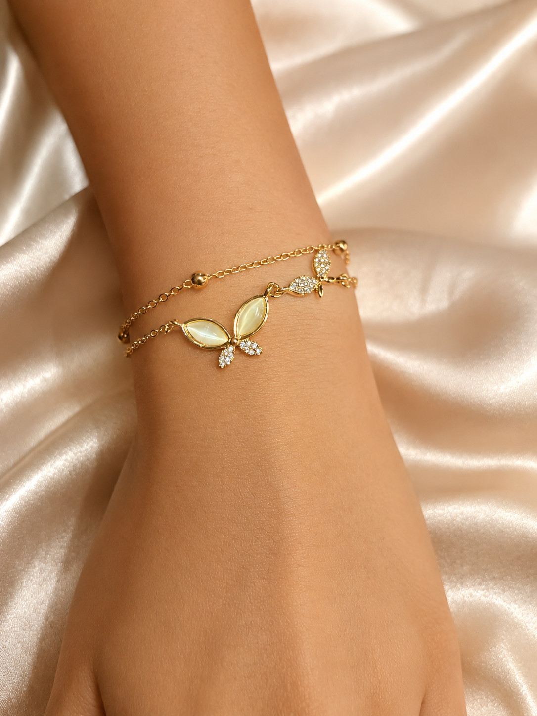 Whispering Wings Bracelet by Ashaarya featuring a dual-chain butterfly design with marquise stones, crafted in 18KT gold plating over 316L stainless steel for lightweight everyday wear.